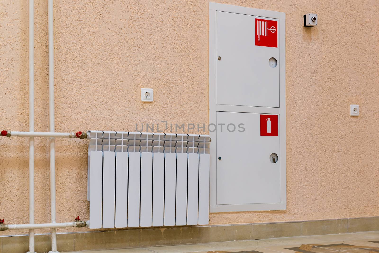 wall of the room with a sink, a fire hydrant and fire extinguisher