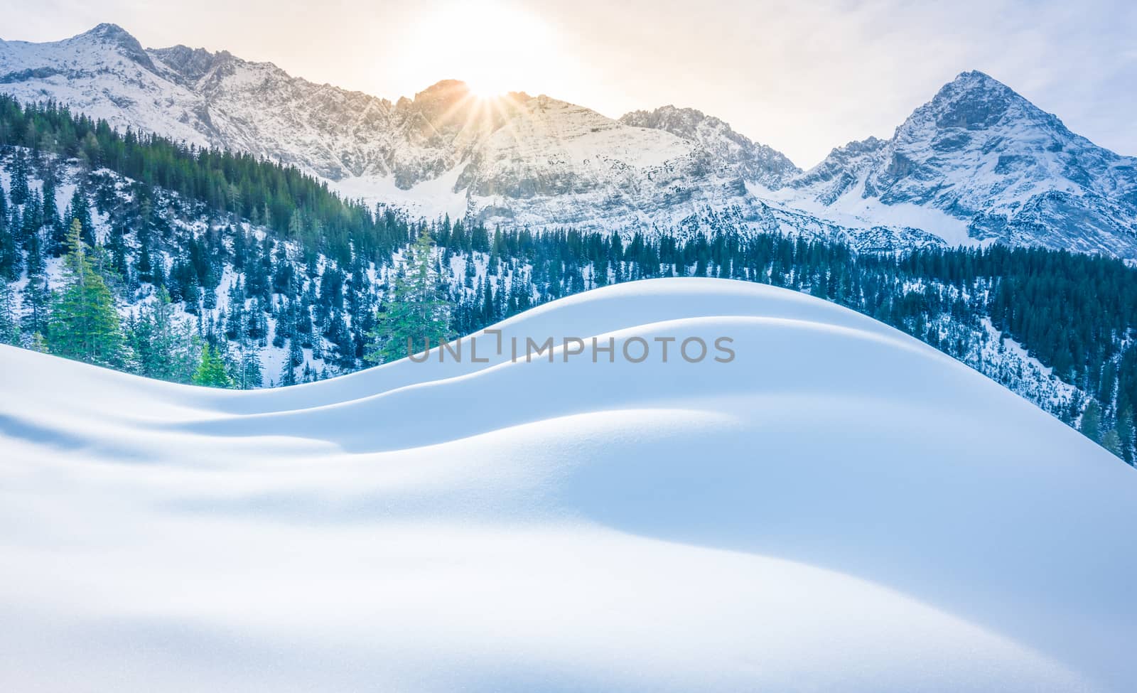 Winter scenery with the Austrian Alps in the background and a big pile of snow in the foreground. Image taken in Ehrwald municipality, Austria.