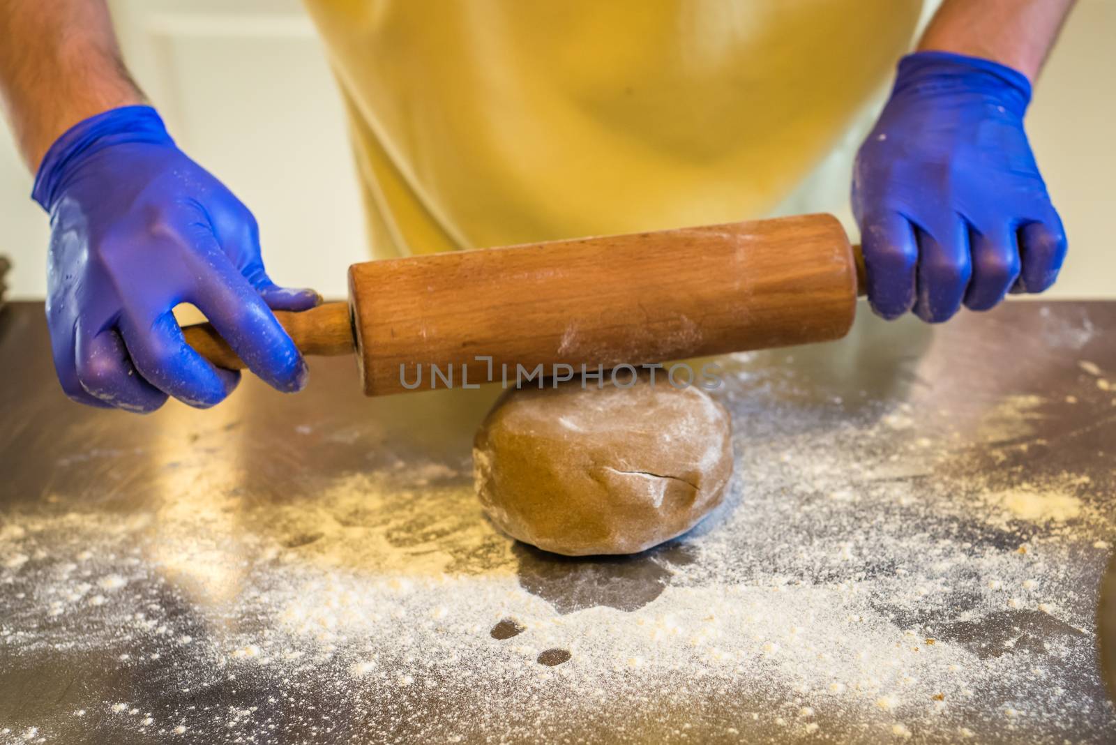 hand rolled out dough with gloves on the table. Preparing cakes