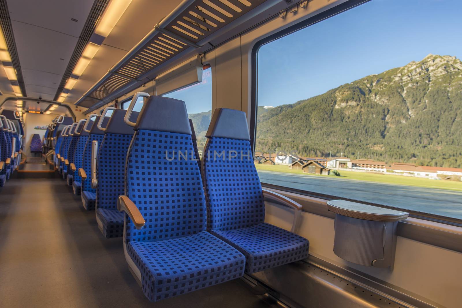 Comfortable chairs on a modern german train, with beautiful alpine view through the window