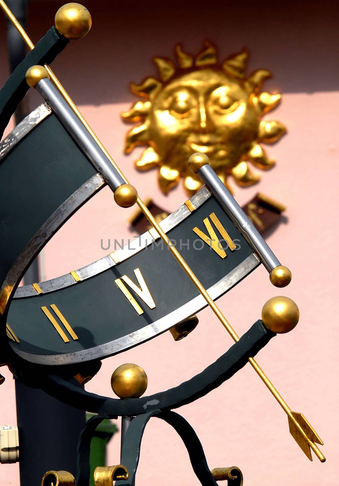 Beautuful Sundial standing near by a house with a sun symbol