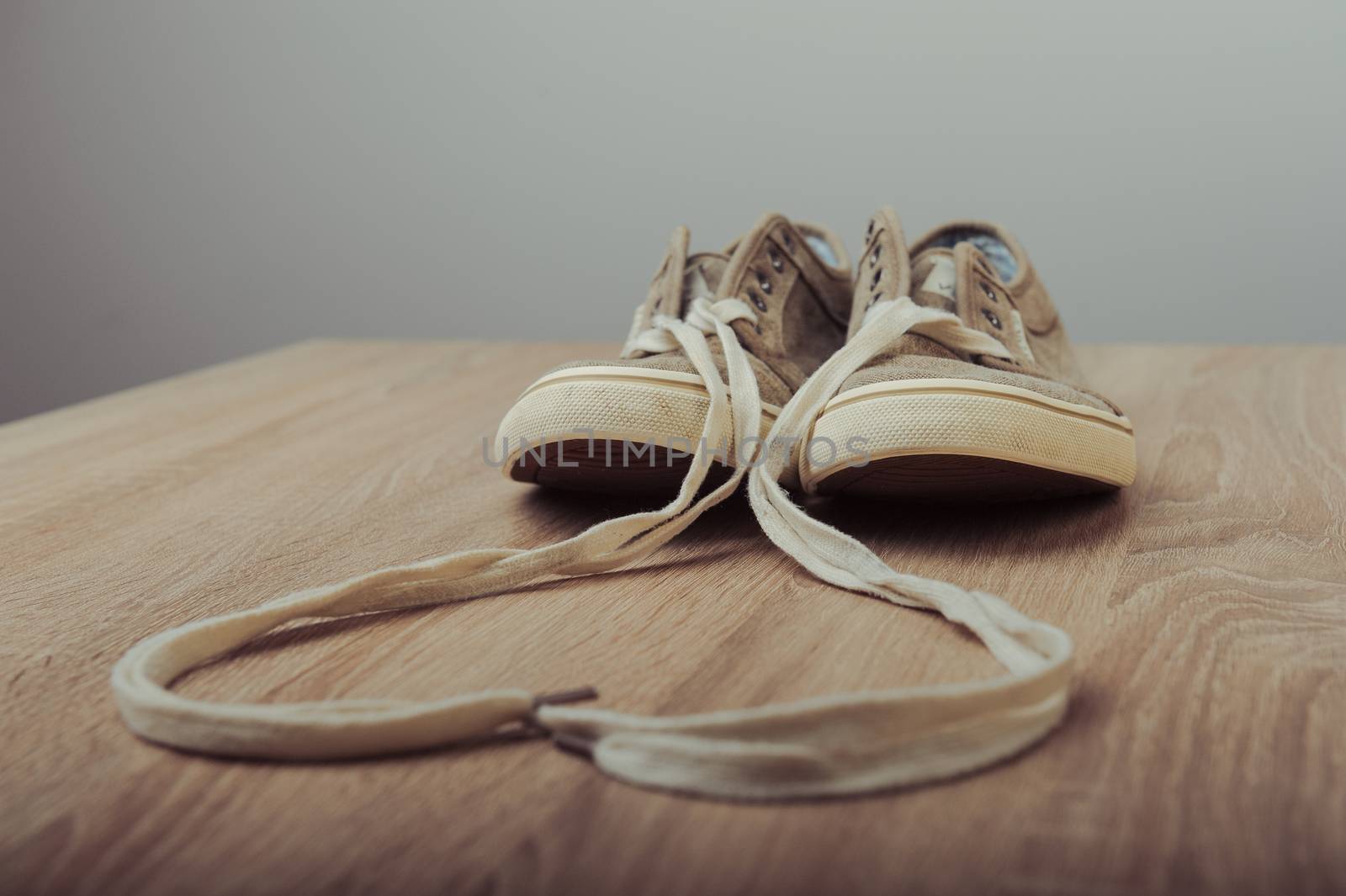 Blue lovely used sneakers on wooden desk