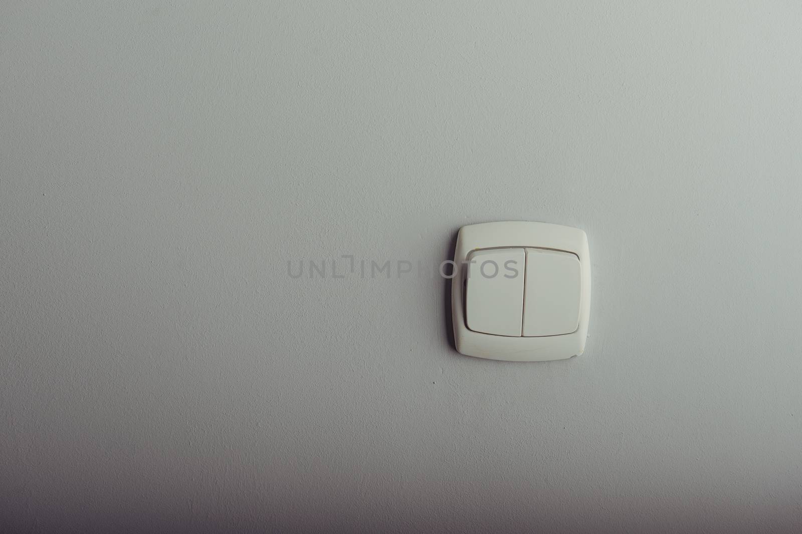 White plastic light switch on a gray wall