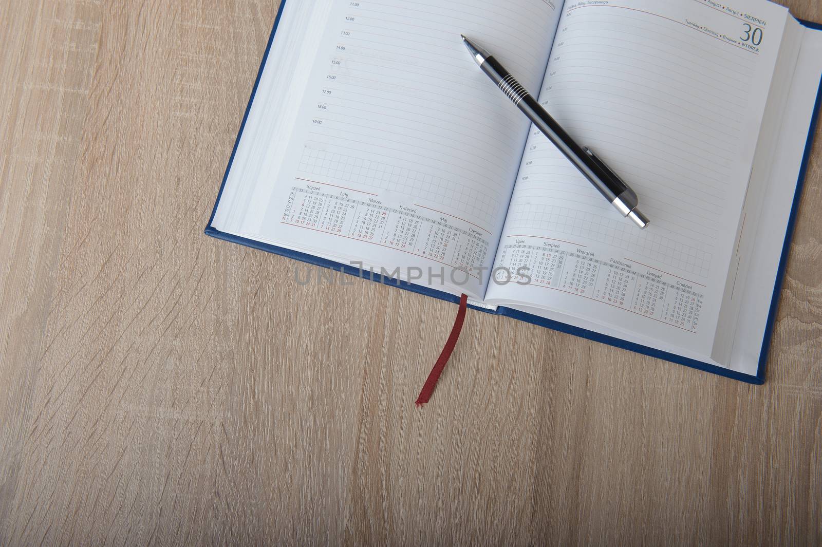Notebook with pen on the wooden desk
