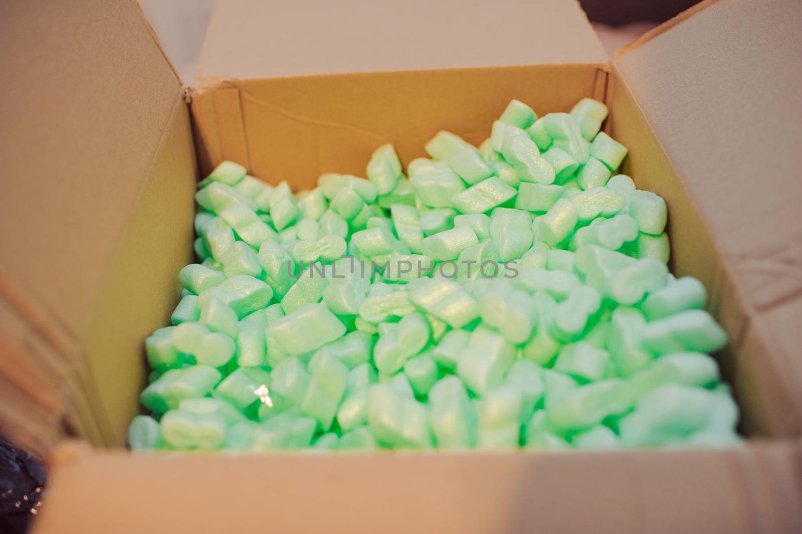 Large packaging box filled with many white styrofoam pellets