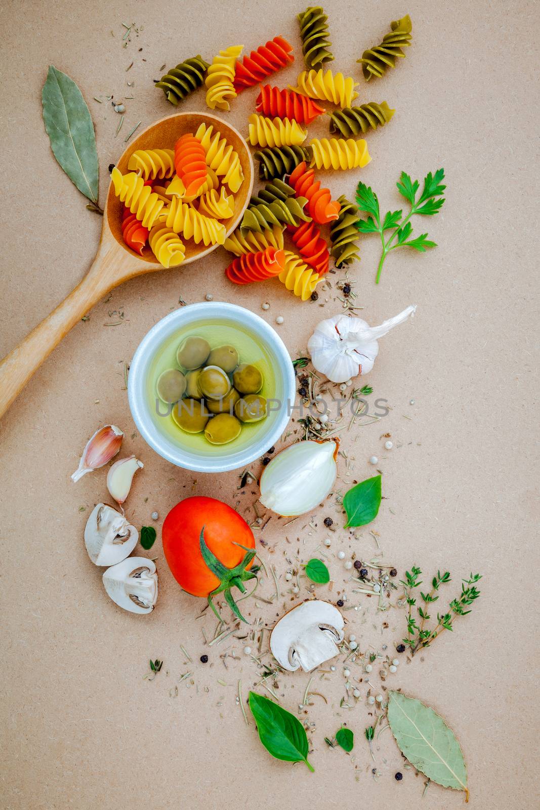 Italian food concept pasta with vegetables olive oil flavored with spices herb rosemary ,thyme,parsley and champignon mushroom set up with brown background.