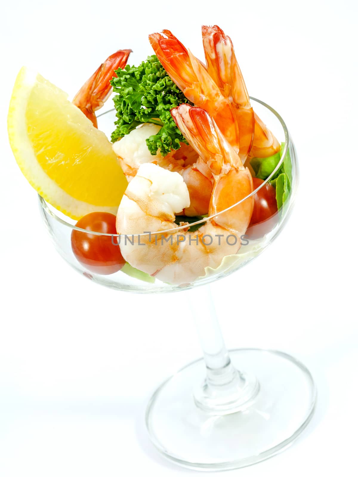 Fresh steamed shrimp in the glass isolate on white background. Boiled prawns with vegetable salad . Boiled prawns with lemon ,parsley and tomato isolated on white background.