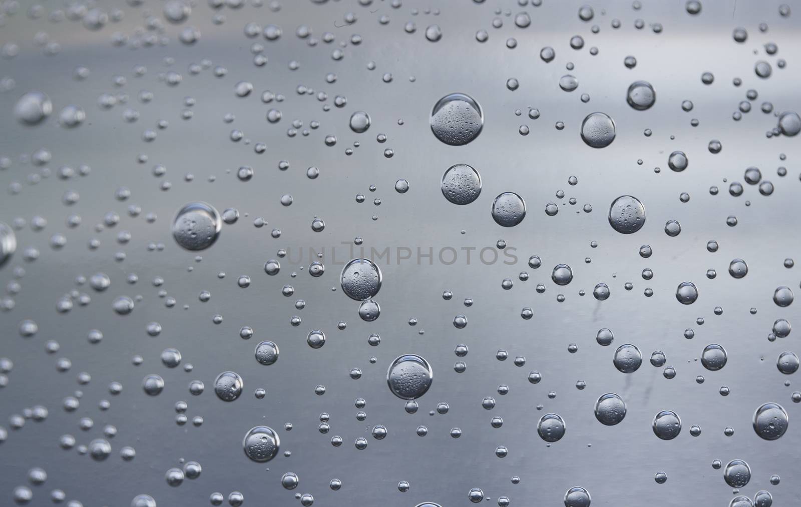 Water drops on blue transparent glass background