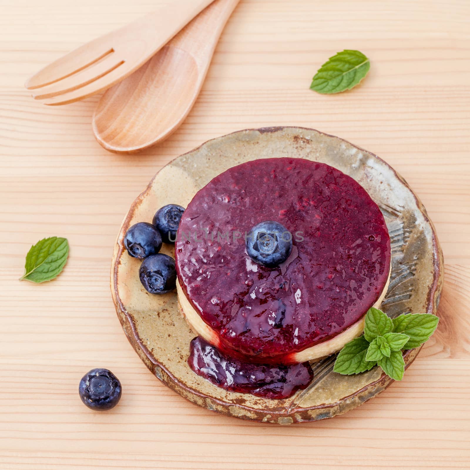 Blueberry cheesecake with fresh mint leaves on wooden background. Selective focus depth of field.