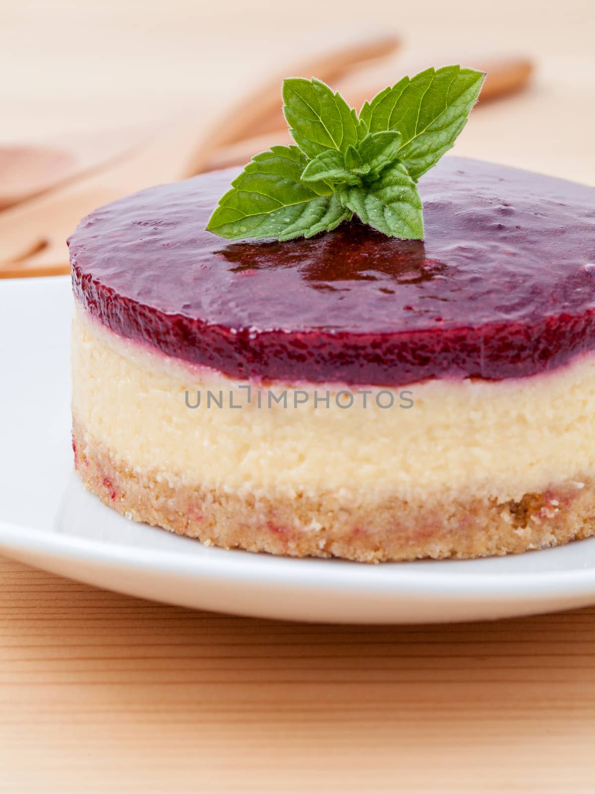 Blueberry cheesecake with fresh mint leaves on wooden background. Selective focus depth of field.