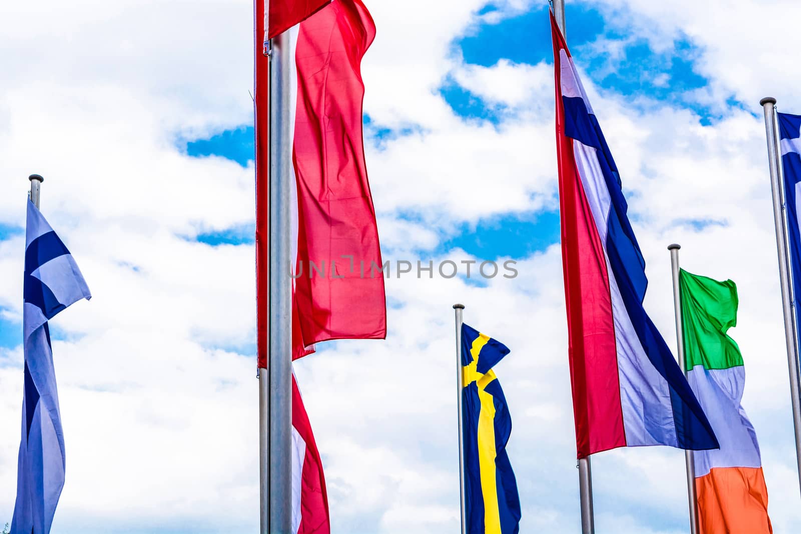 Several Europe countries flags arranged in front of a blue sky.