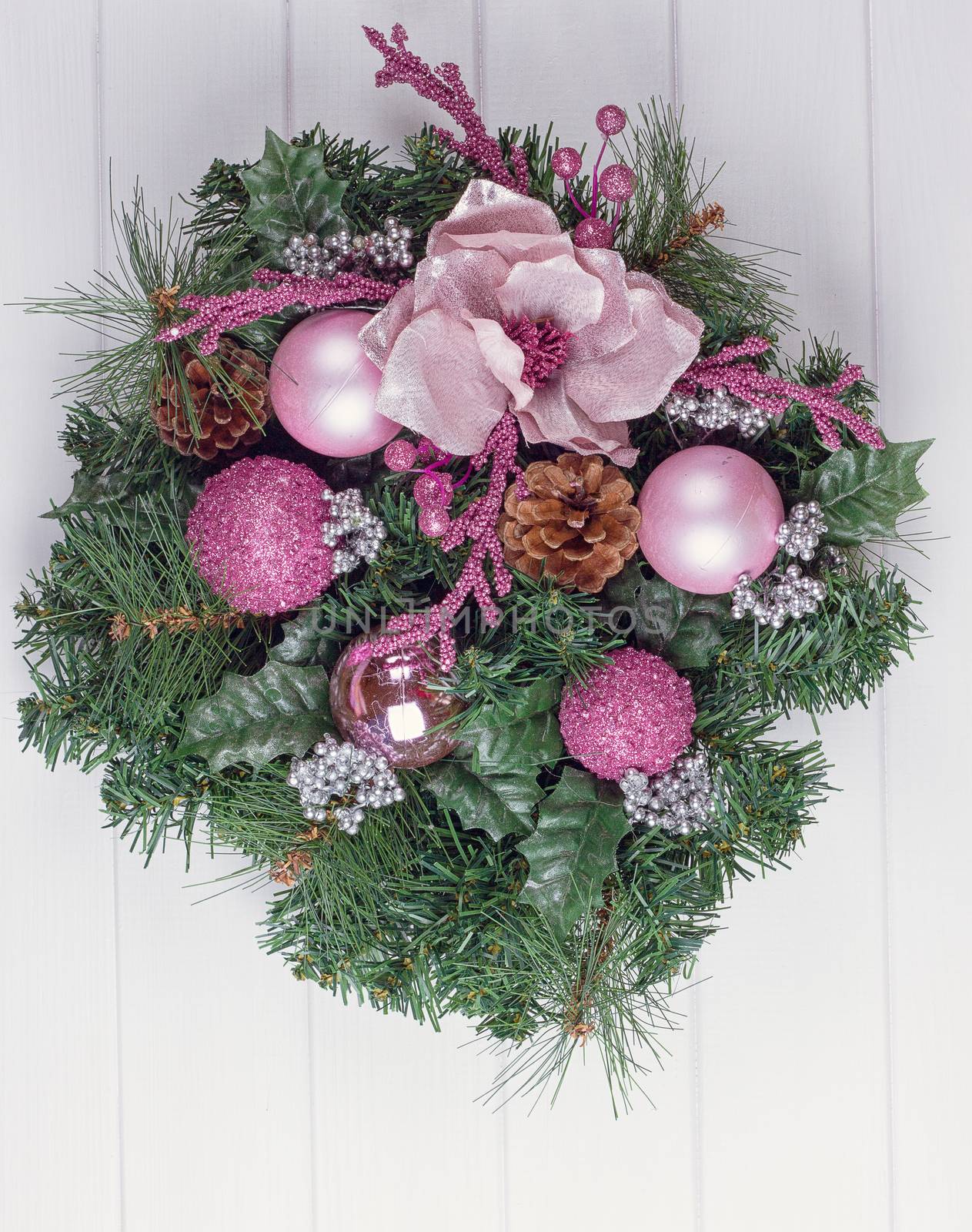Christmas wreath on a rustic white wooden front door.