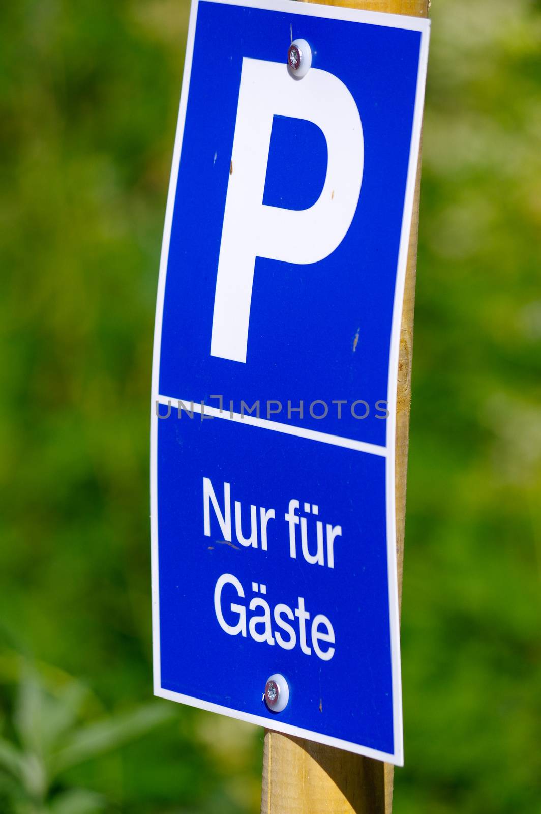 blue parking sign with a big P on it, green background. only for guests - in German by evolutionnow