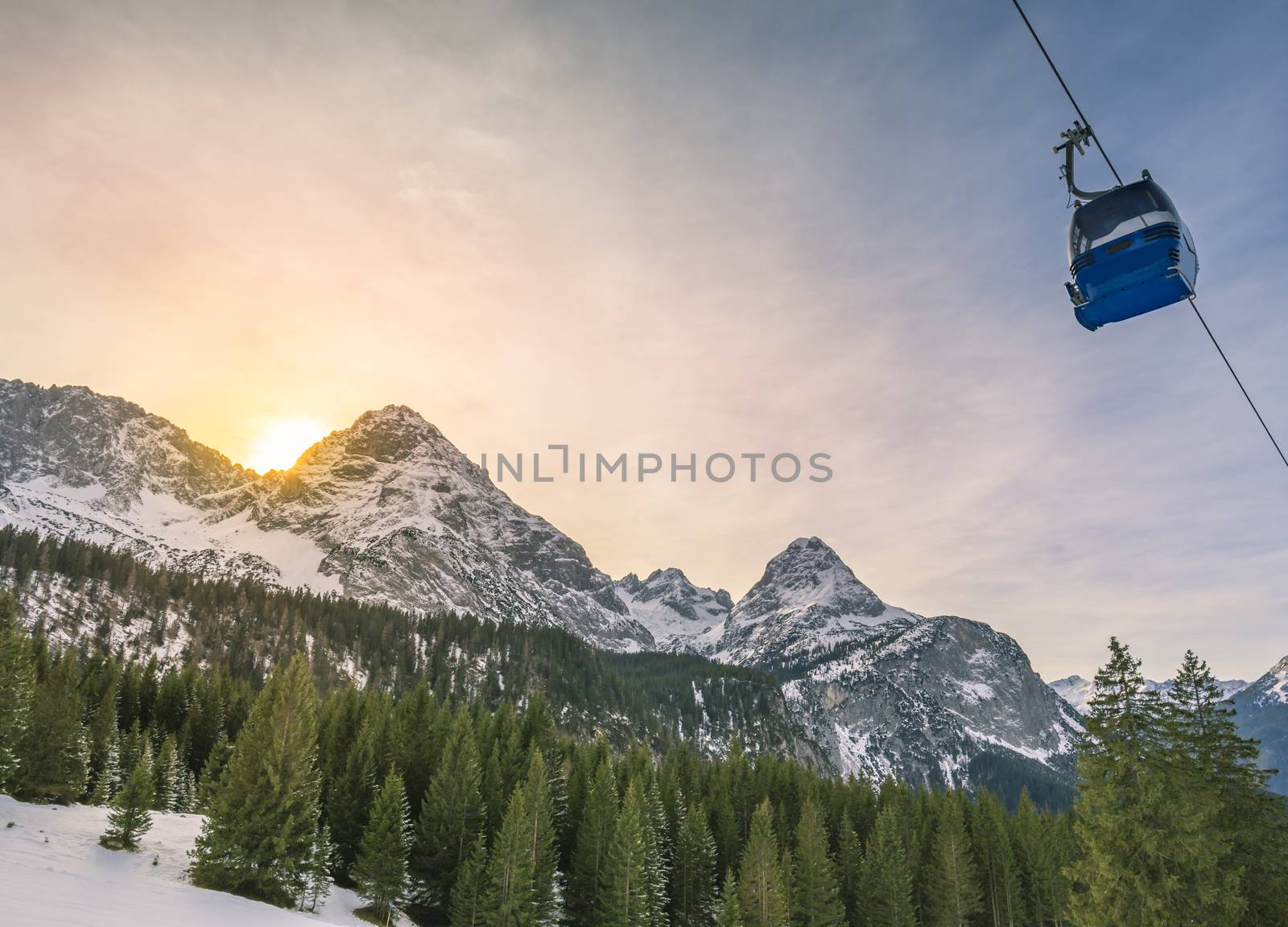 Winter landscape with evergreen fir forests, the Austrian Alps mountains and a cable car, in Ehrwald municipality, Austria.