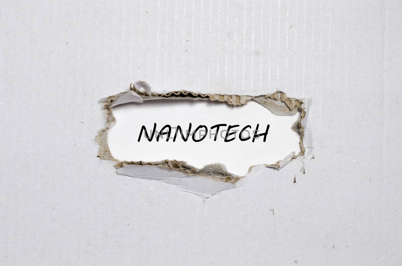The word nanotech appearing behind torn paper by eenevski