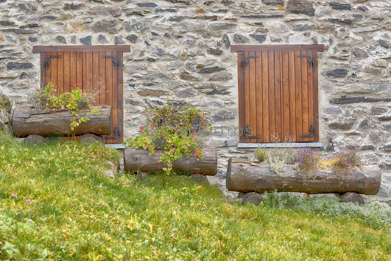two windows and three flower boxes on the sloping lawn