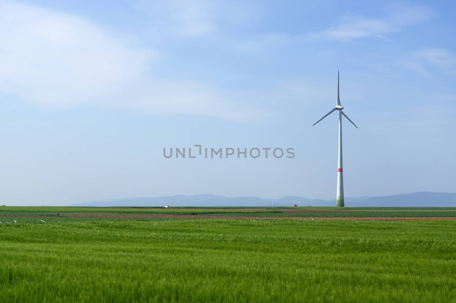 green meadow with Wind turbines generating electricity by evolutionnow
