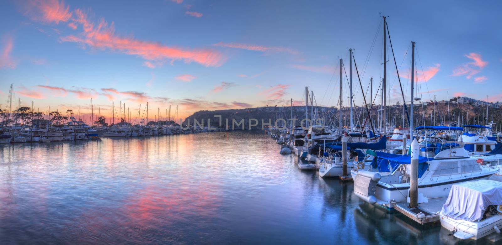 Sunset over sailboats in Dana Point harbor by steffstarr