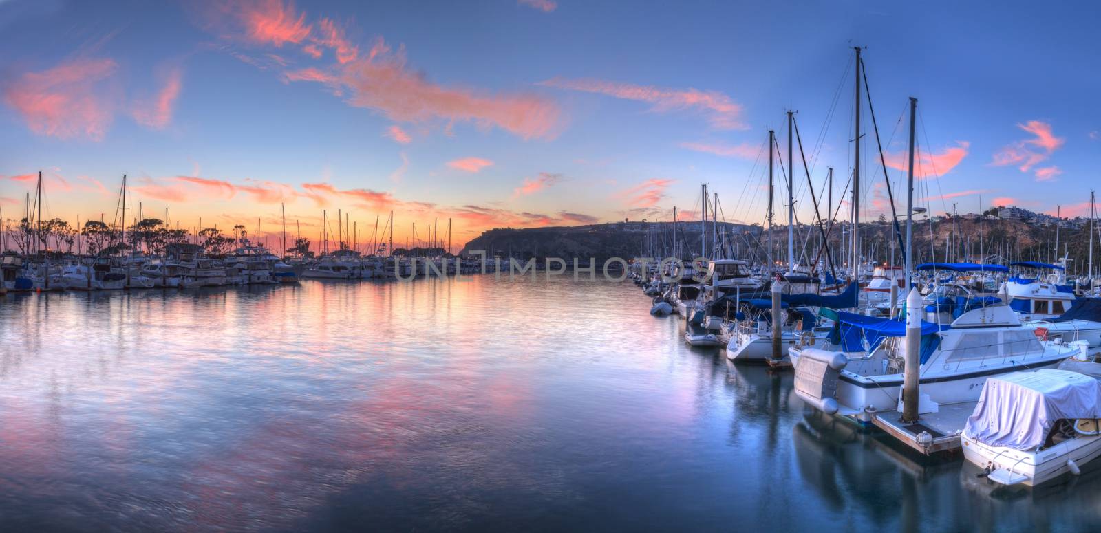 Sunset over sailboats in Dana Point harbor in the fall.