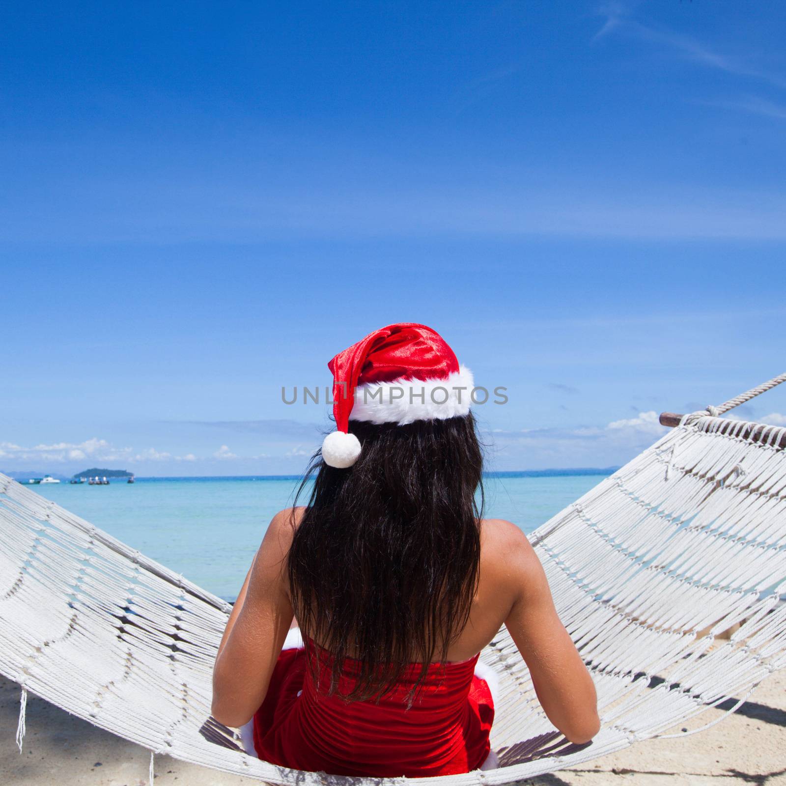 Woman in hammock on tropical beach celebrating Christmas