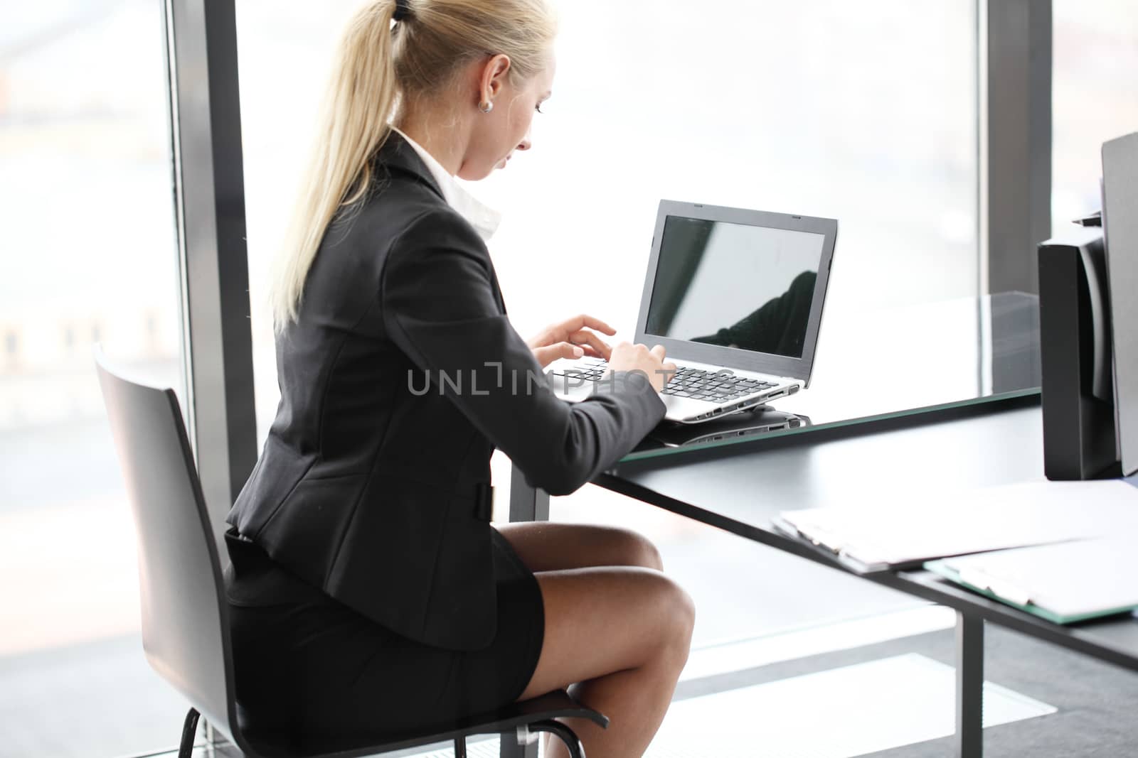 Young pretty business woman with laptop in office