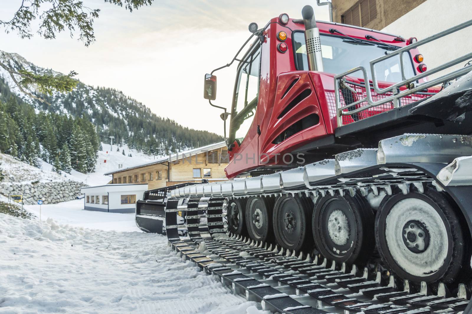 Tracked snow groomer car, parked near an alpine mansion, high in the Austrian Alps, near the village Ehrwald, district Reutte