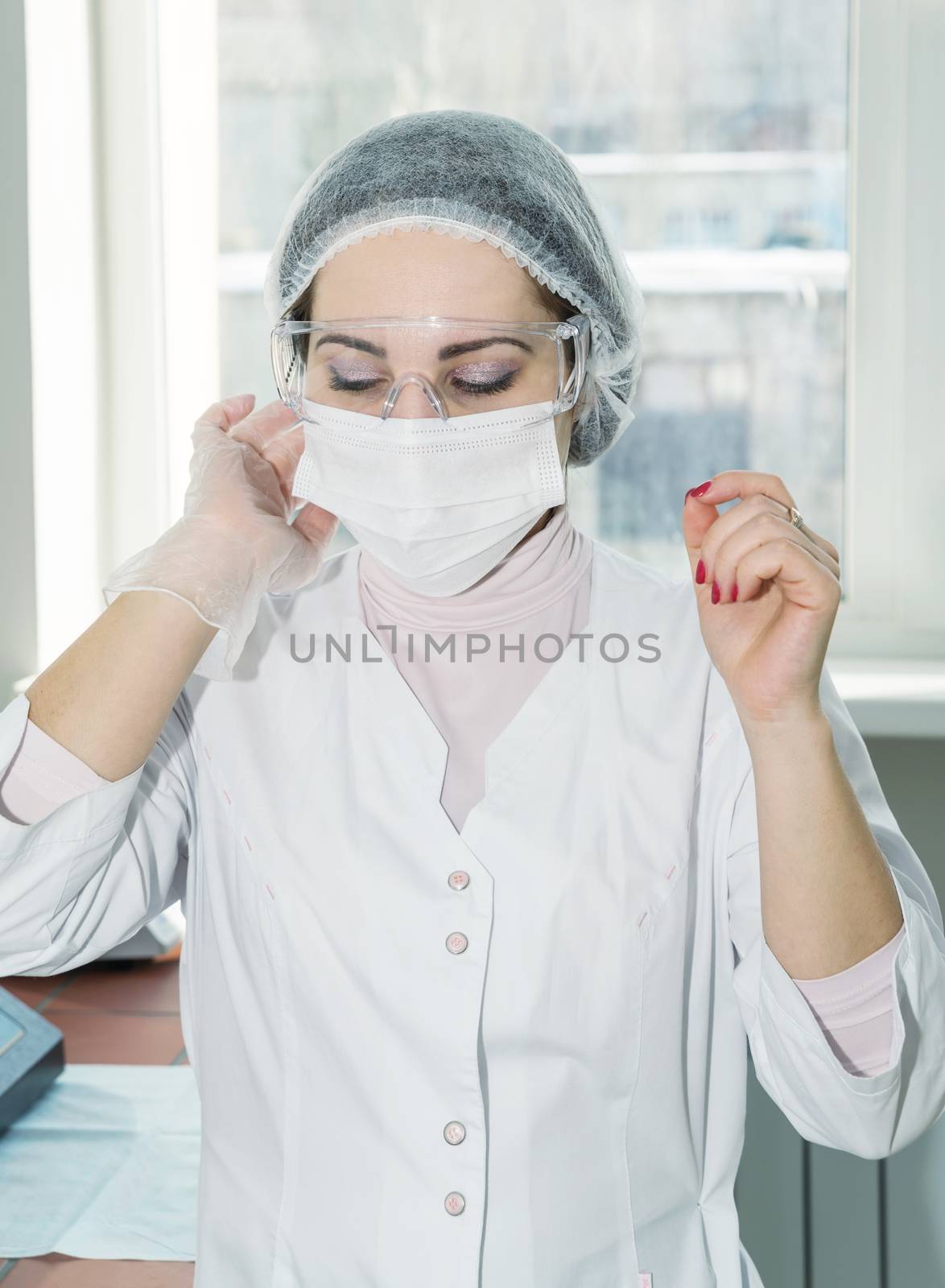 Woman scientist in a white protective clothing preparing for the experiments in the laboratory