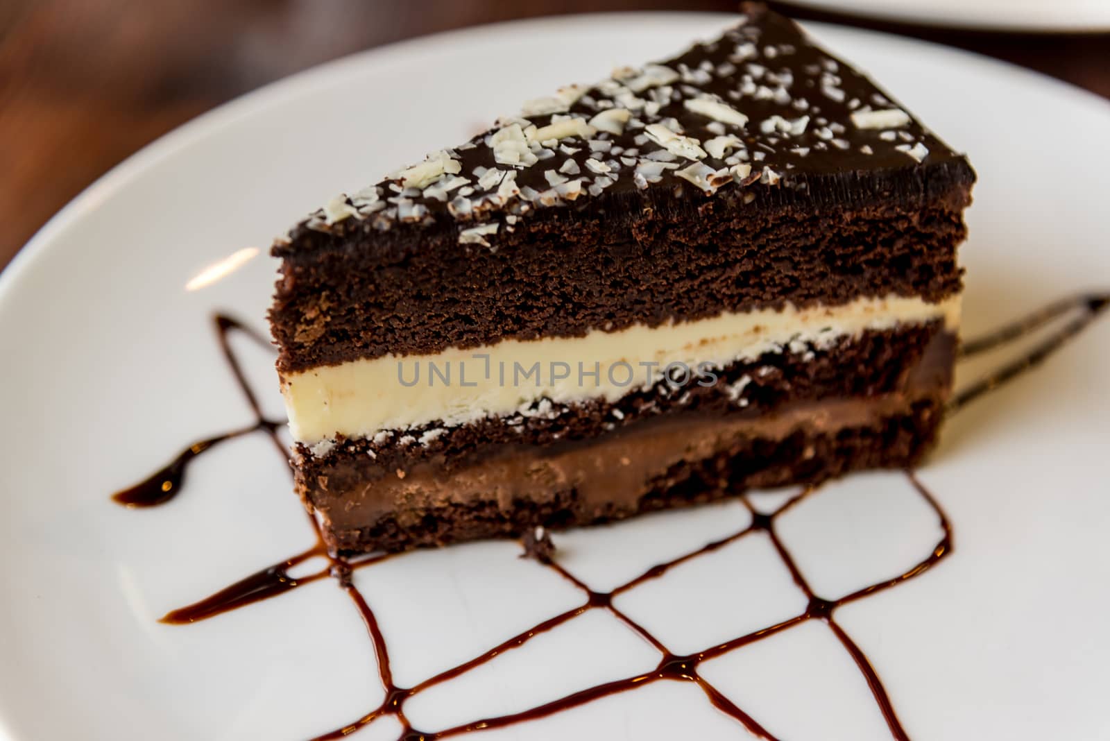 Slice of chocolate cake on plate by olgavolodina