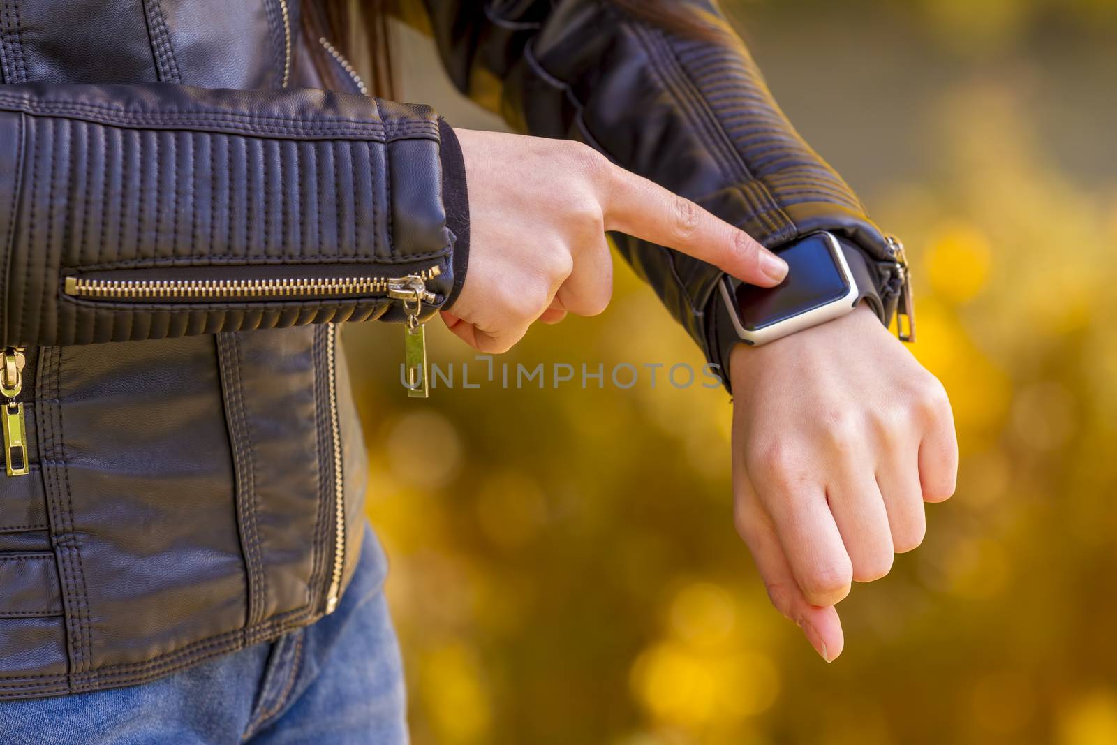 Young girl wears smart watch with touchscreen. Focus on hand!