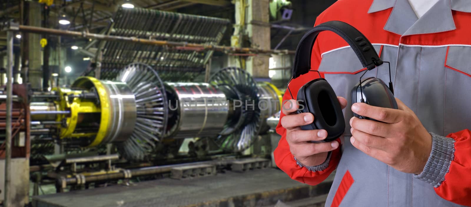 Worker with protective headphone at man hands at industrial factory