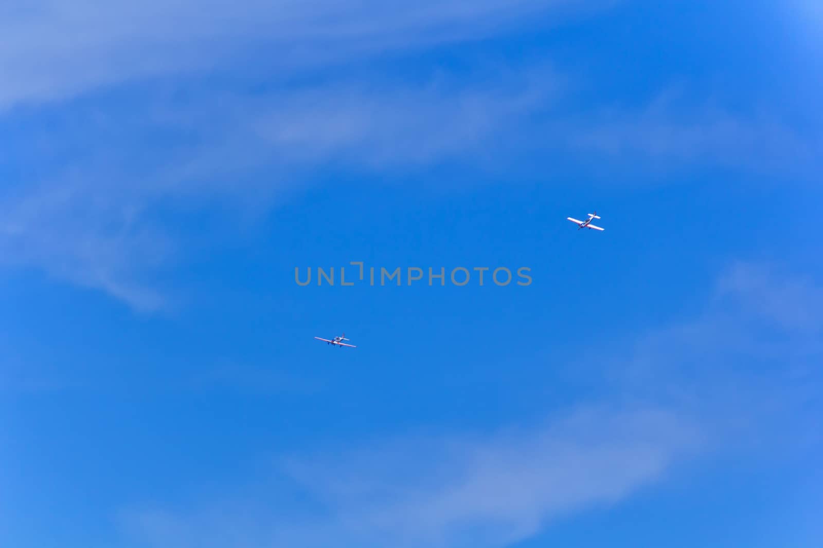 Photo of two flying military airplanes in blue sky