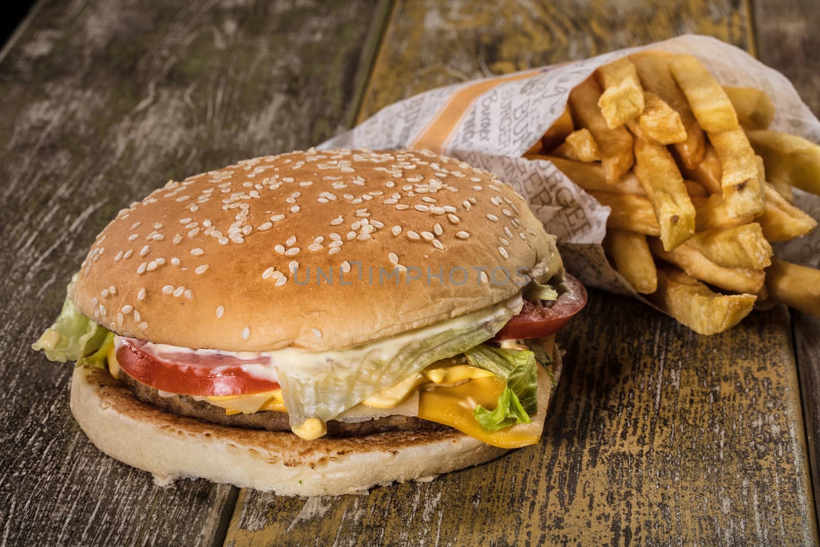 Hamburger and fried potato on an old wooden desk