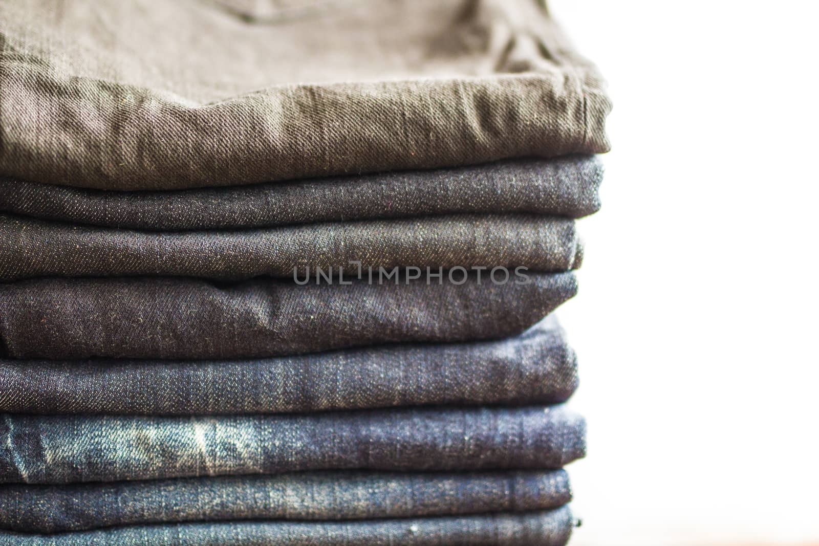 Stack of jeans on white background