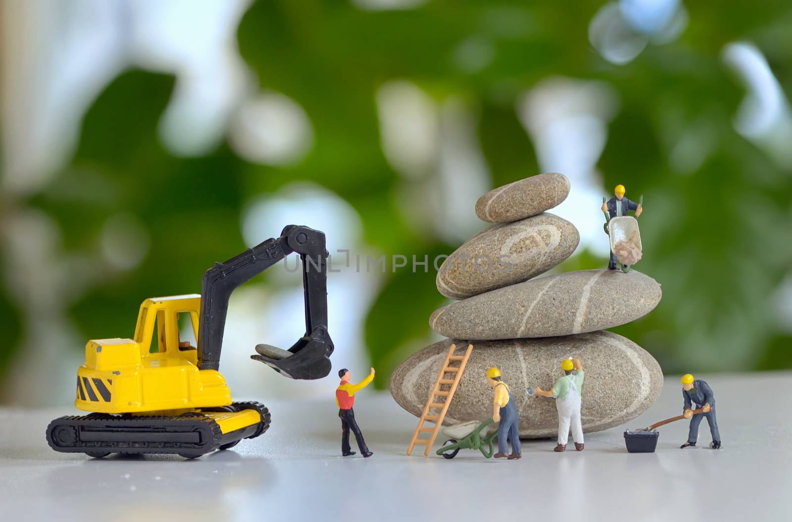 Pebbles stack and figurines of construction workers