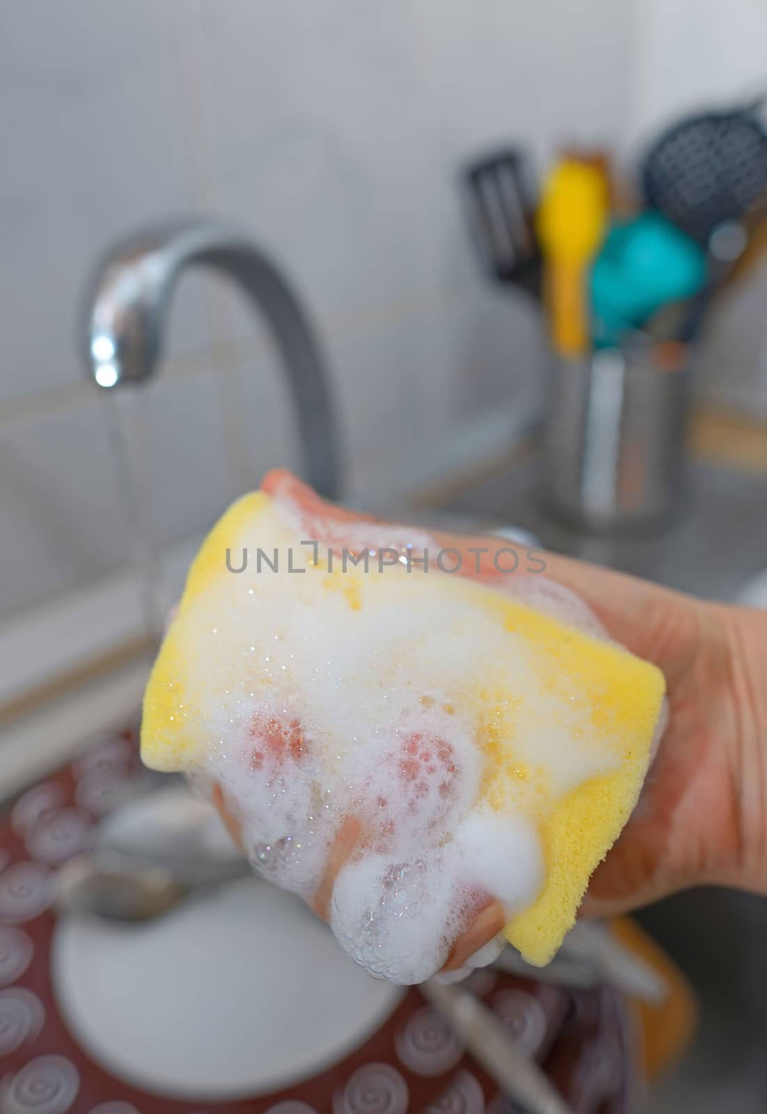 Close up hands with gloves of woman washing dishes