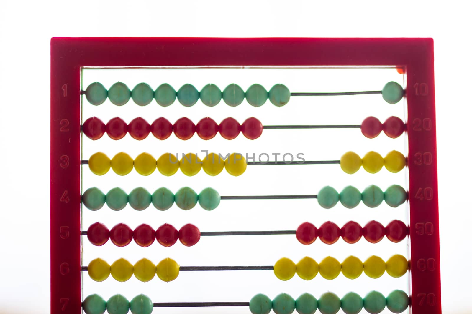 Toy abacus with rainbow colored beads on a white background