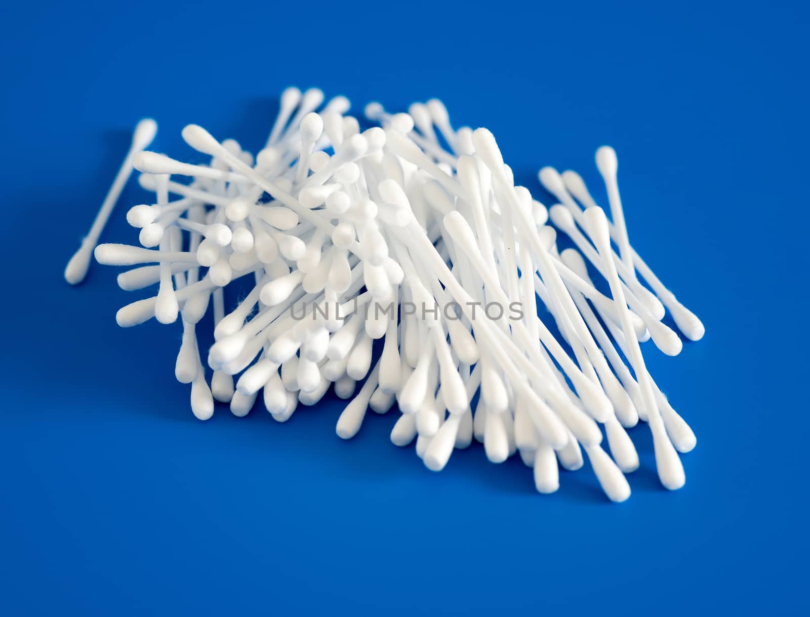 Cotton buds lie hill on a blue background