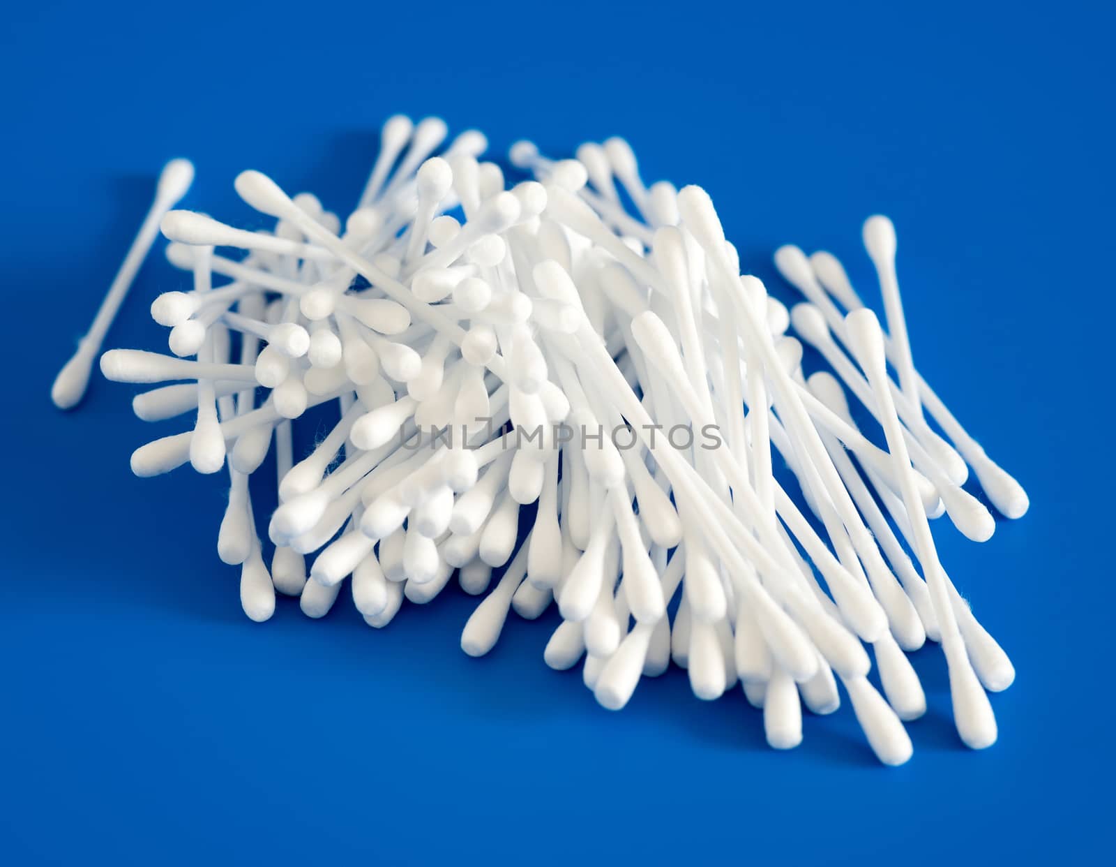 Cotton buds lie hill on a blue background