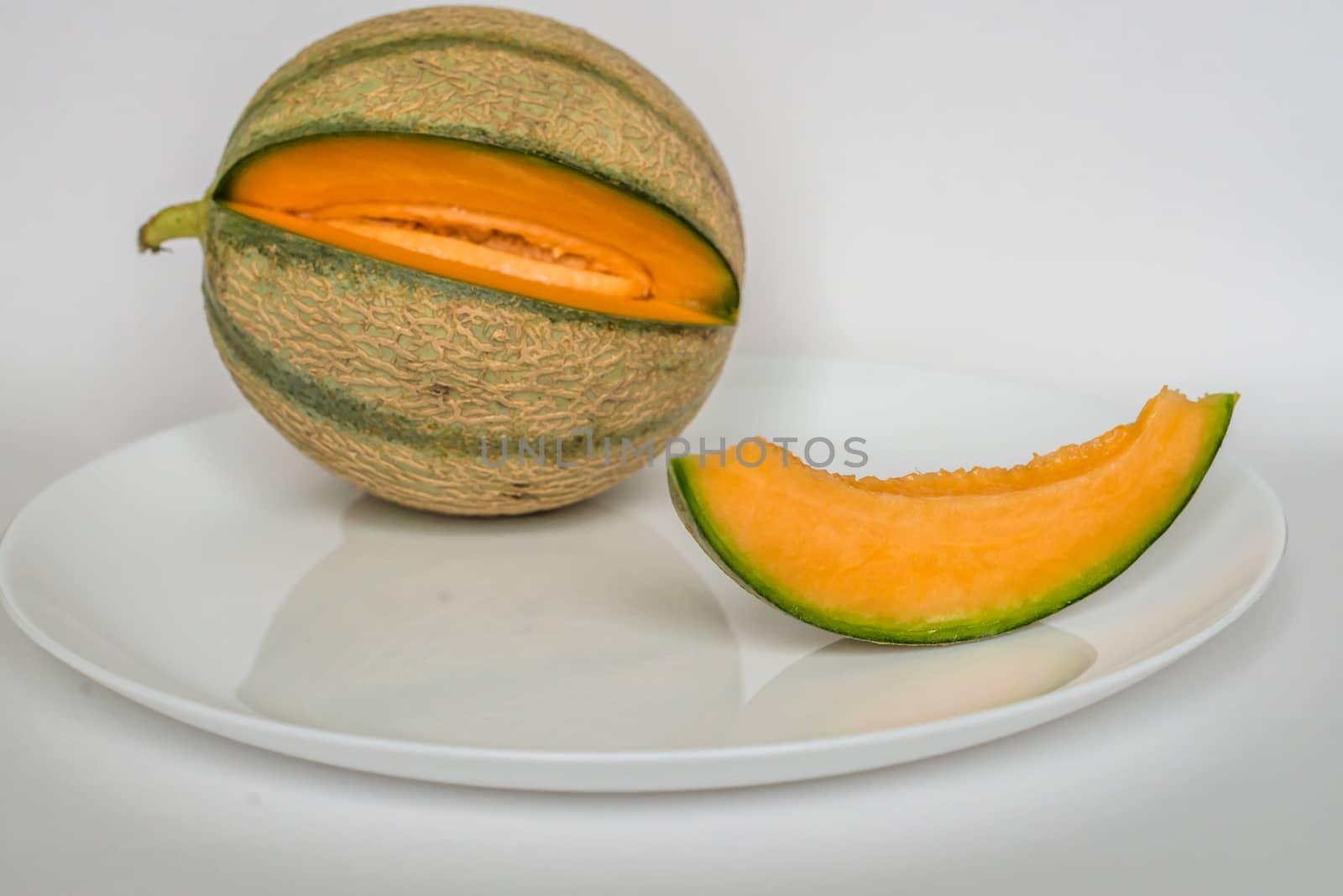 ripe melon with slice on white background by okskukuruza