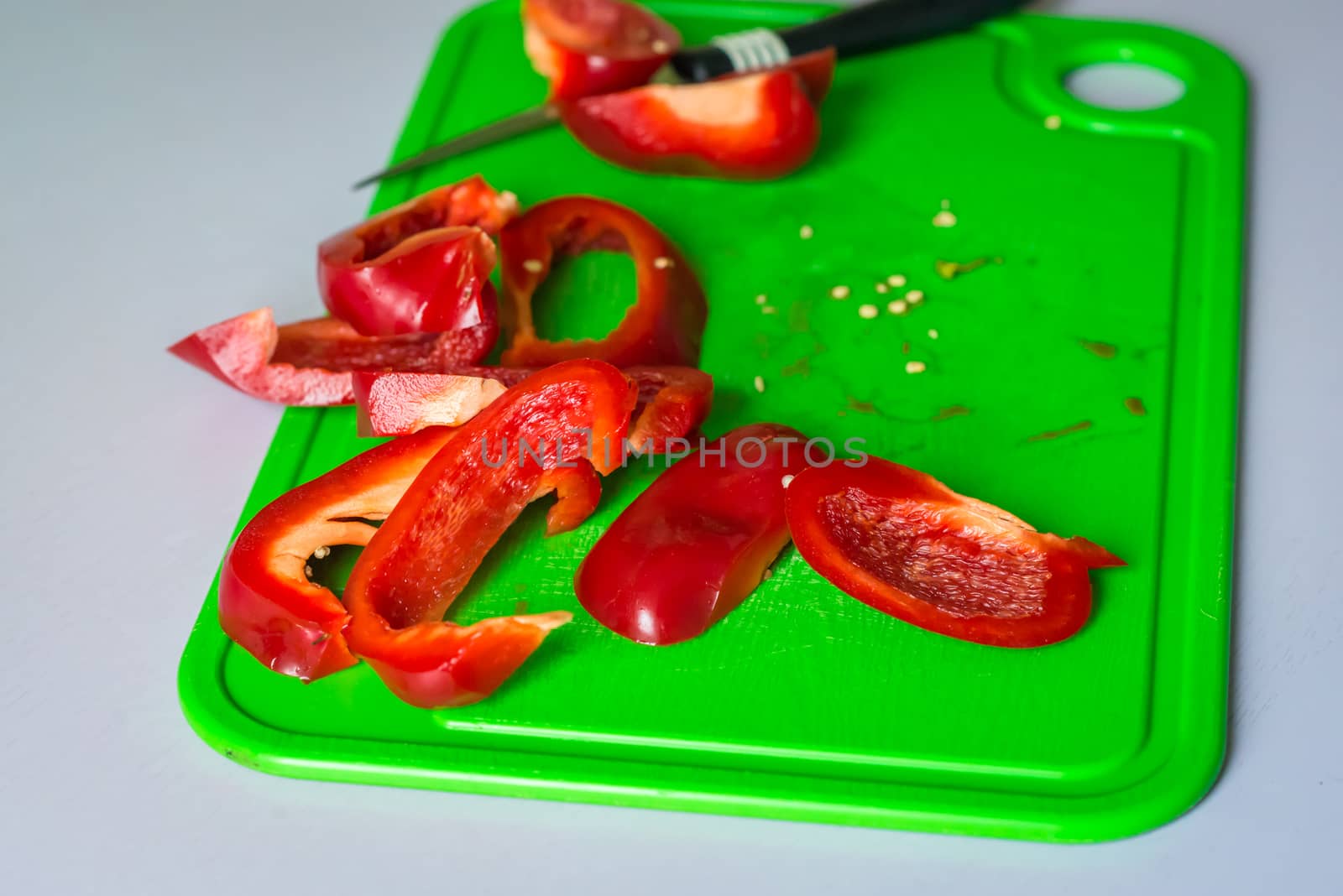 chopped red bell pepper on the plastic Board