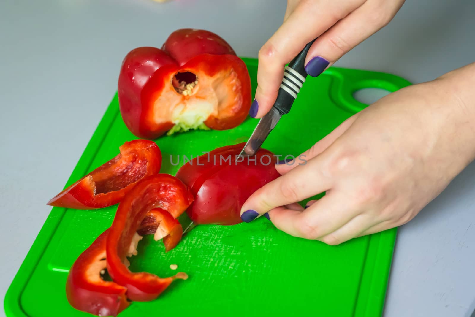 hand cut red bell pepper on green plastic board