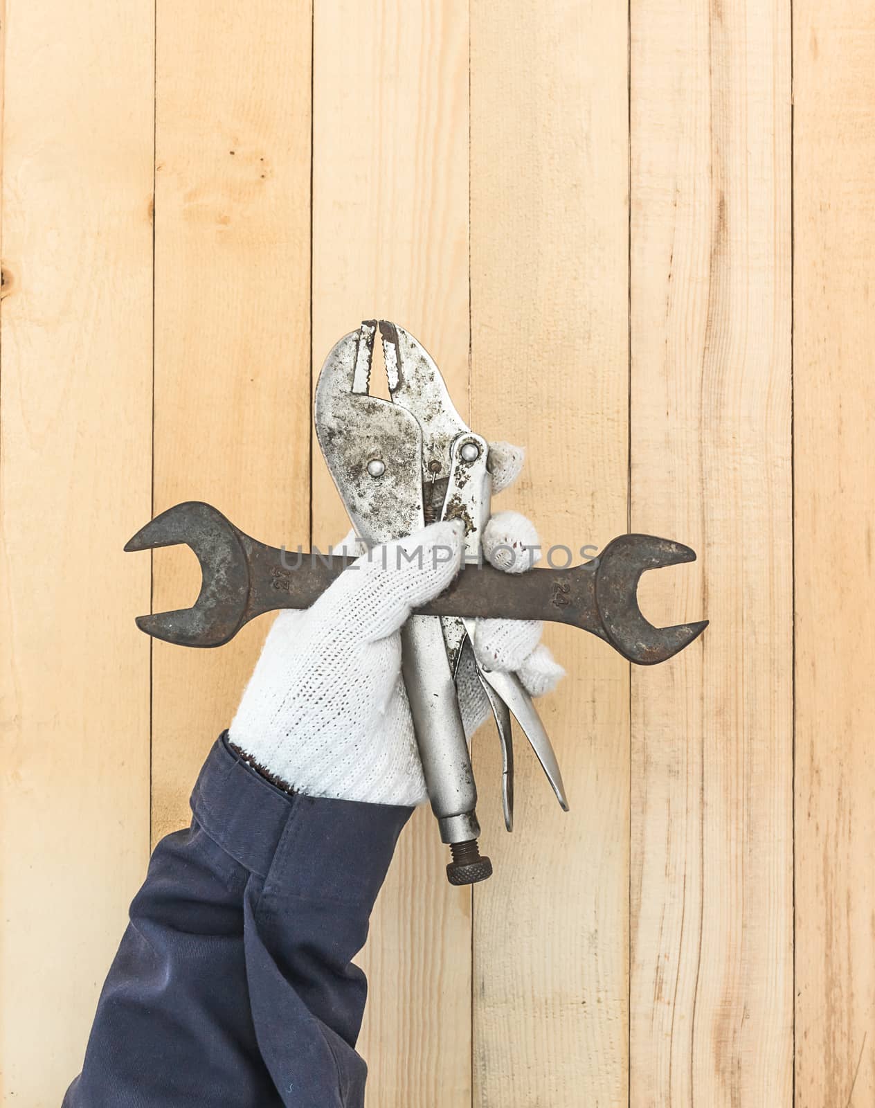 Hand in glove holding Spanner and Adjustable wrench by stoonn