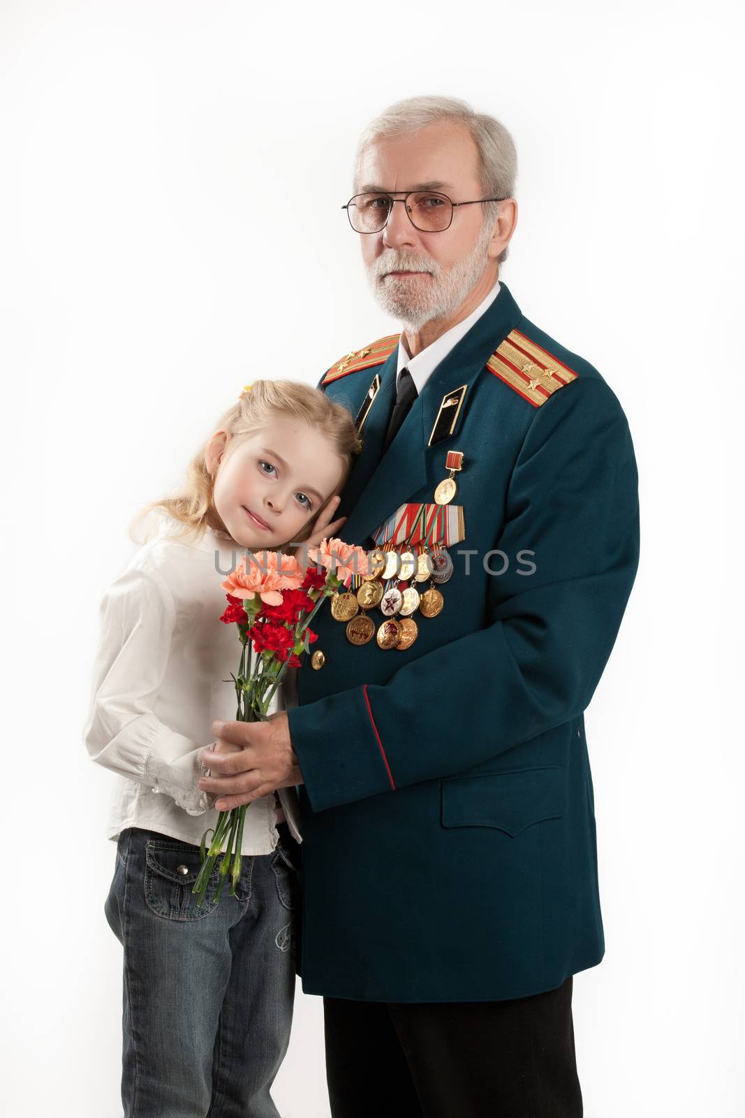 Old man in army uniform with rewards and beautiful little girl on isolated studio background