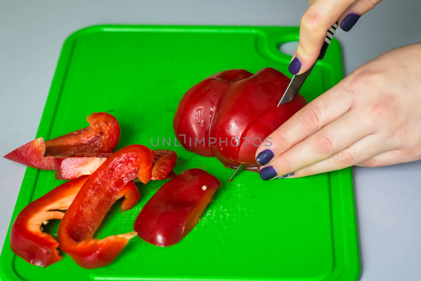 hand cut red bell pepper on a gold board