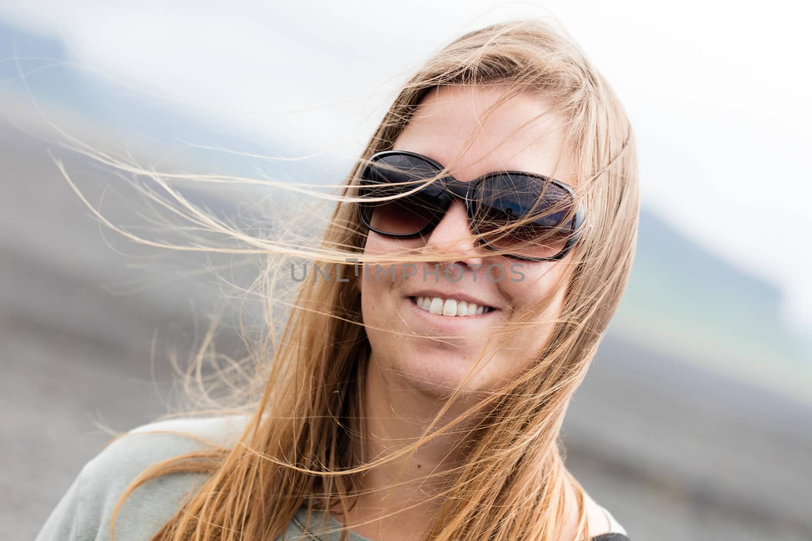 Young woman wearing sunglasses laughing in the fall