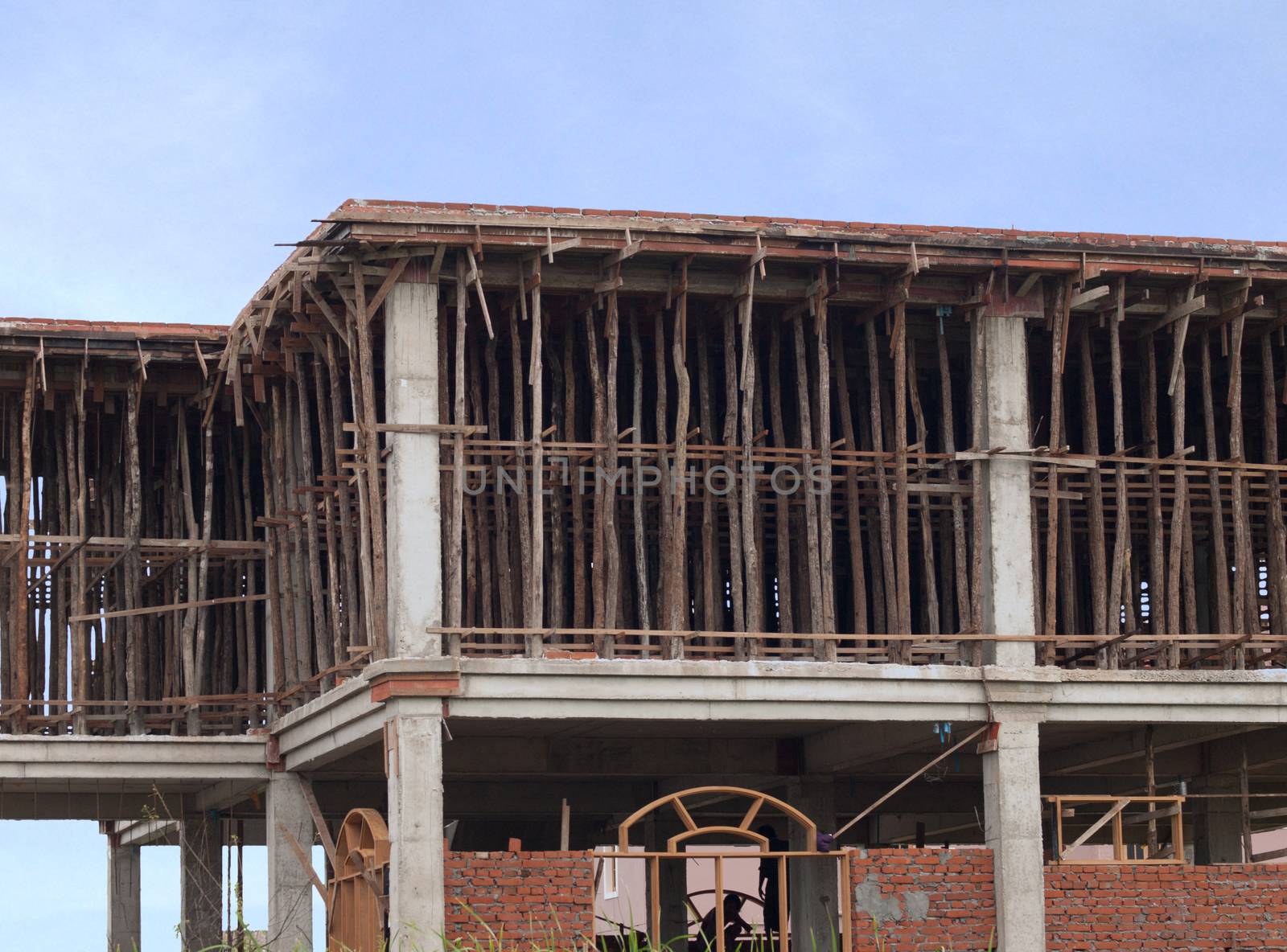BUILDING UNDER CONSTRUCTION WITH SUPPORTING TIMBERS IN MYANMAR