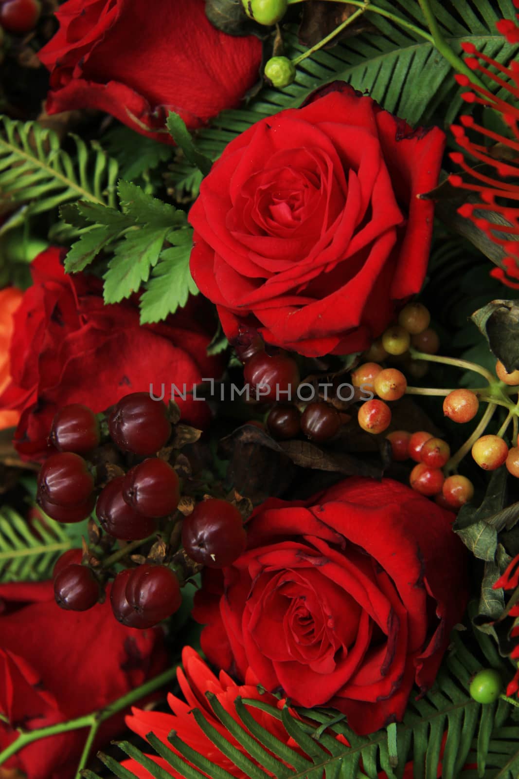 Red roses in a mix flower wedding arrangement in red