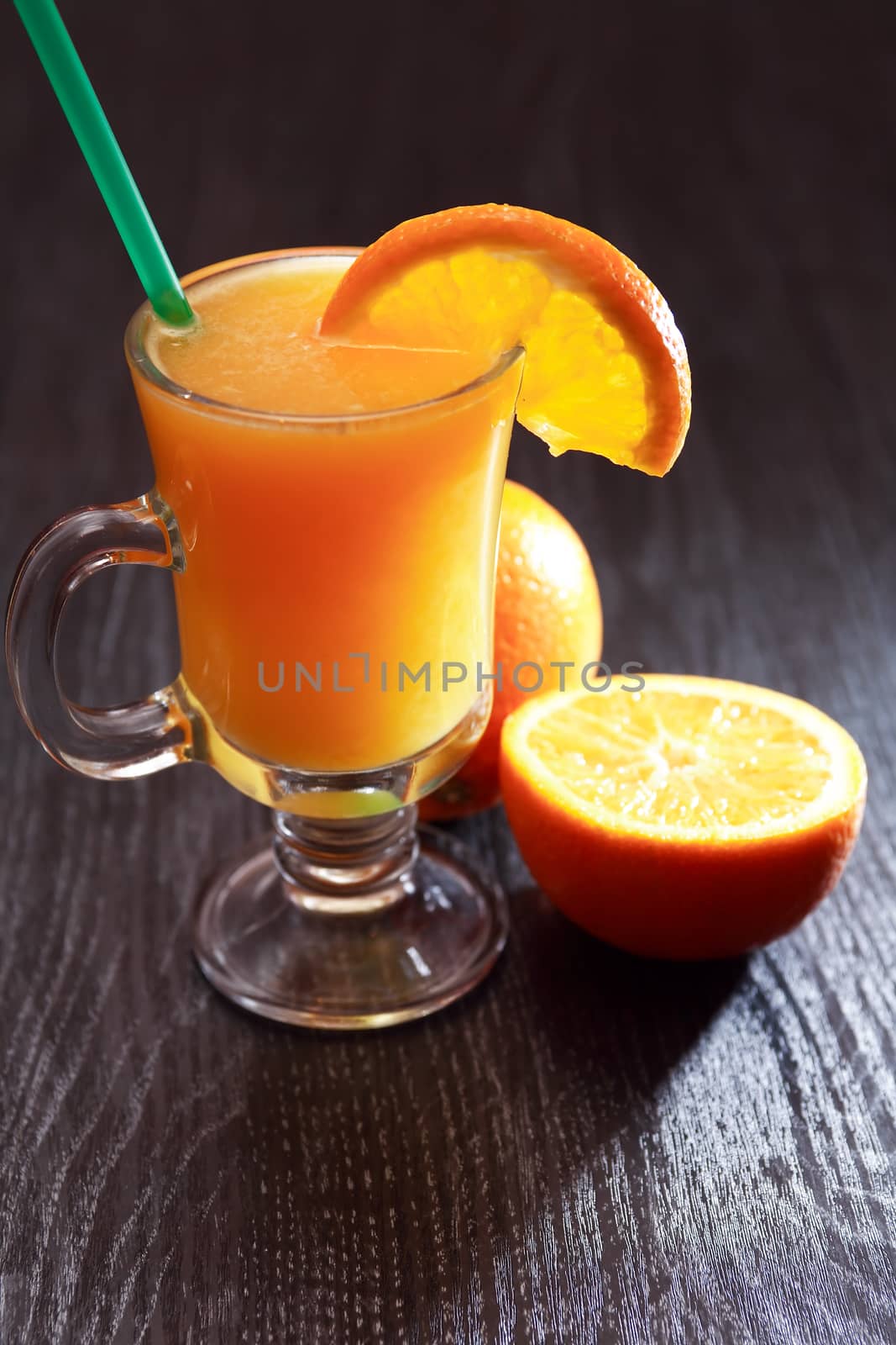 Nice goblet full of orange juice near fruits on table