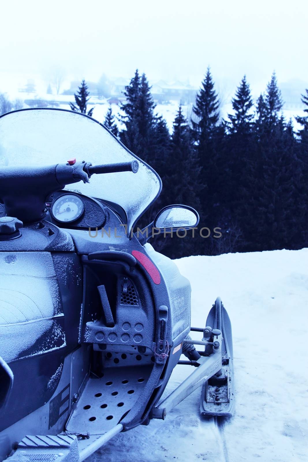 Side view of Snowmobile in winter mountains with forest