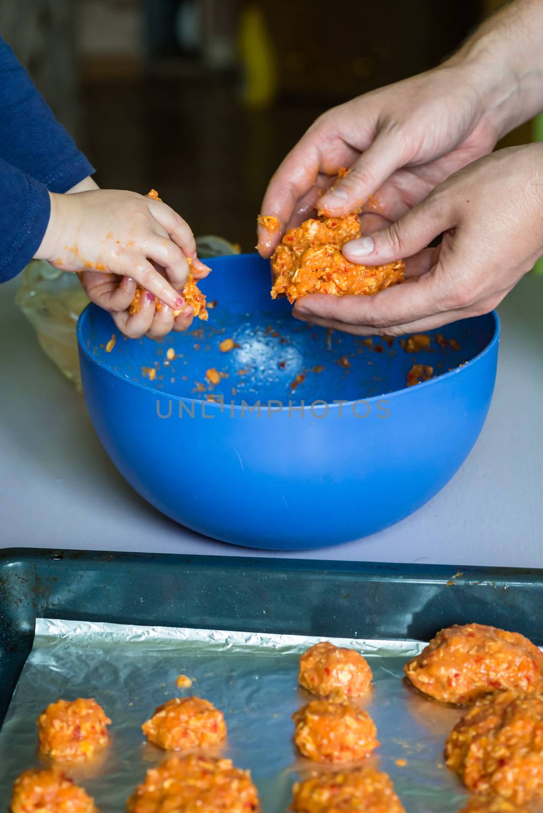 Children and dad hands prepare the raw meatballs